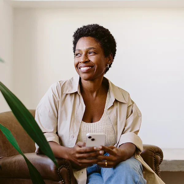 a woman sitting on a couch holding a phone