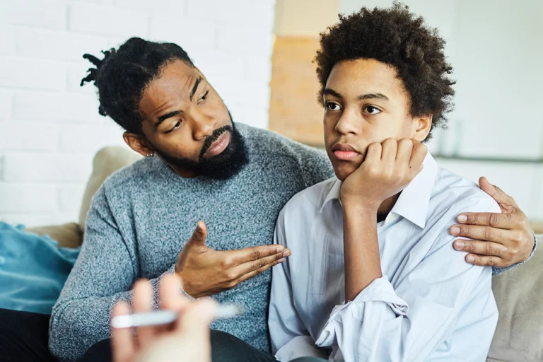 a father talks to his son during family therapy